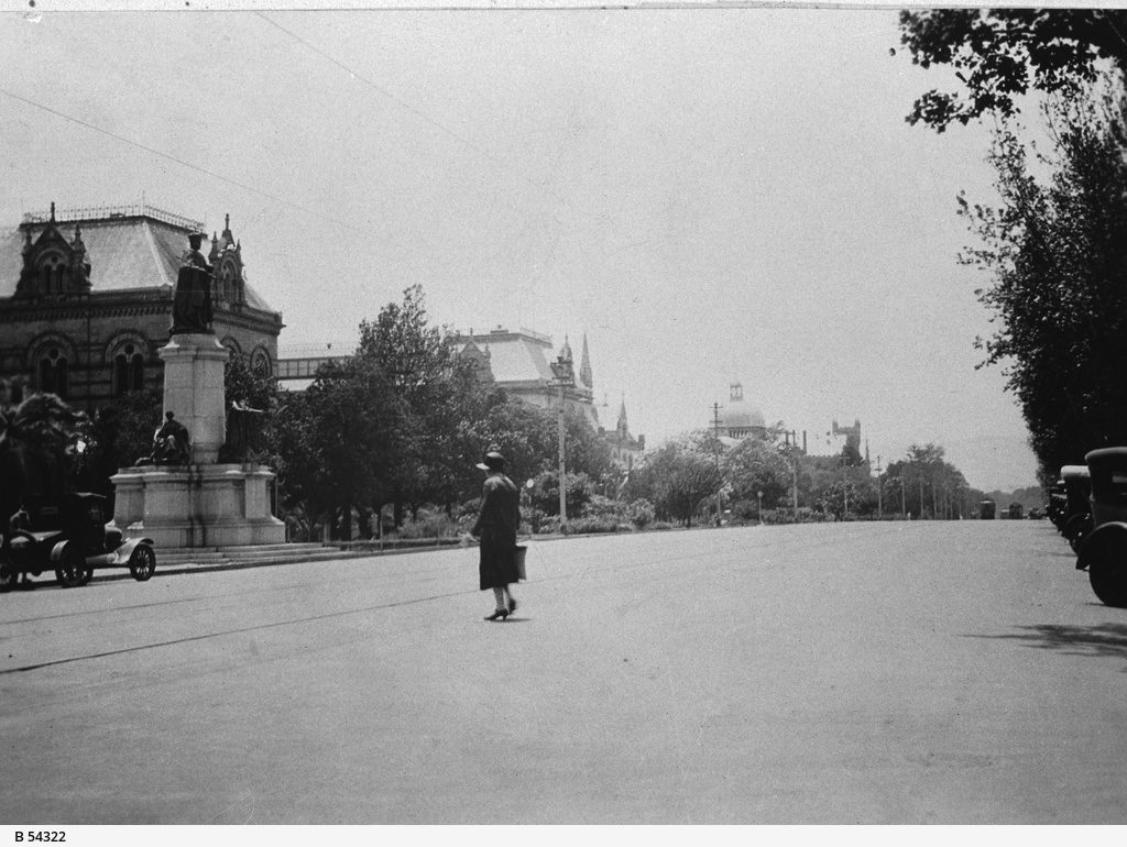 A woman crosses North Terrace, Adelaide. General view of North Terrace, c. 1928. Image via State Library of South Australia.